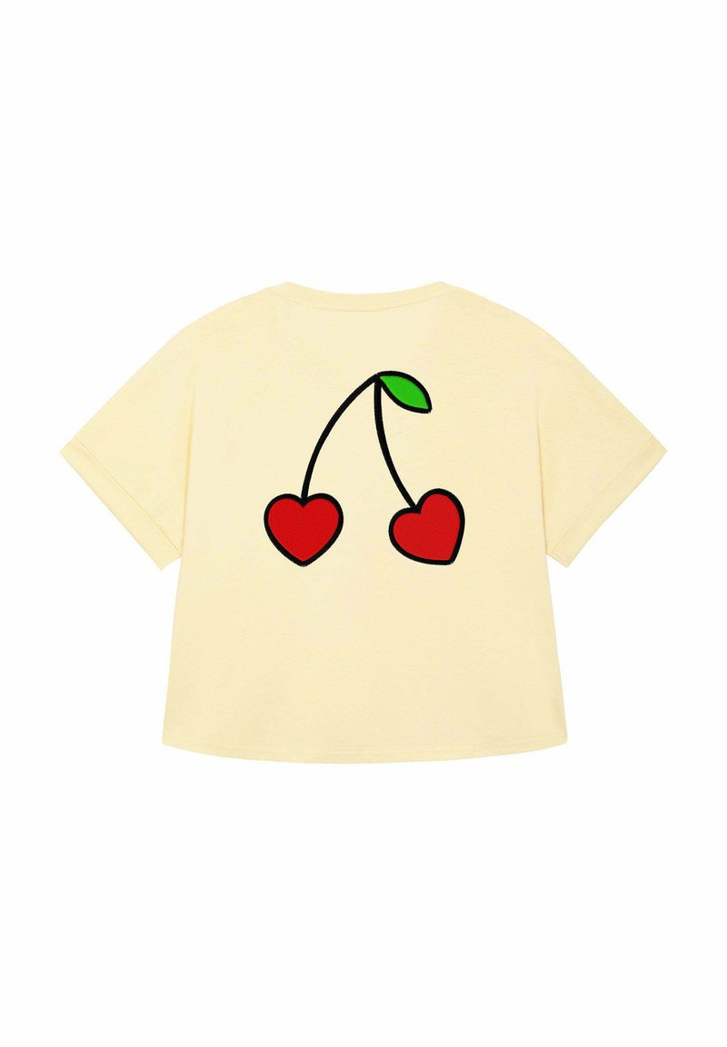 T-shirt oversize gialla con una grafica di due cuori rosse collegate da un gambo nero e una foglia verde sul retro.
