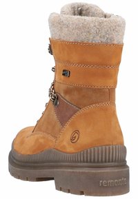 Bota de senderismo de ante marrón con un cuello de piel sintética beige y esponjoso, con acentos de cuero marrón en contraste, cordones y una suela de goma texturizada.