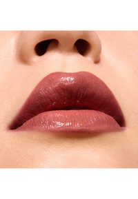 Close-up van lippen met een matte, middelmatige rozenkleur. De textuur is glad met een glanzende afwerking op de onderlip. De huid toont subtiele details.