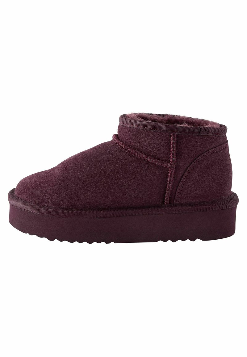 Bottines bordeaux en daim, avec un bout rond, un intérieur doux et une semelle en caoutchouc épaisse et texturée avec un motif en zigzag.