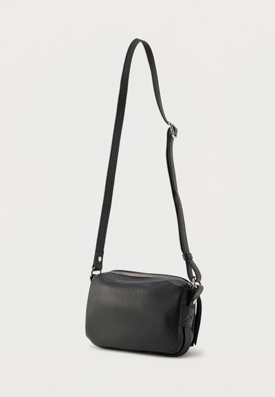 Μαύρη δερμάτινη τσάντα ώμου με υφή εξωτερικά, κλείσιμο με φερμουάρ και ρυθμιζόμενο λουρί. Συμπαγές ορθογώνιο σχήμα, μινιμαλιστικός σχεδιασμός.