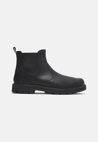 Botas Chelsea de cuero negro con paneles laterales elásticos, lengüeta de tirón y suela de goma resistente, con punta redonda y un marcado minimalismo en la marca.