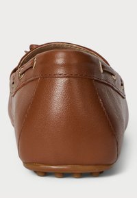 Rjave usnjene mokasinke z zaobljeno obliko, ki imajo zlatovato kovinske detajle in teksturirano podplat s malimi zaobljenimi izbočkami.