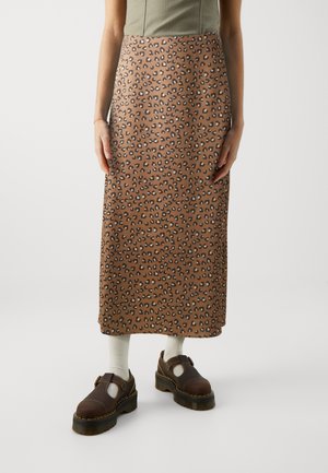 Brun leopardmønstret midiskjørt med rett design, laget av et glatt materiale. Sammen med brune sko og kremfargede sokker.