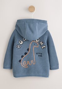 Hoodie tricoté bleu avec capuche, affichant un motif dinosaure. Détails comprenant les mots brodés "ROAD HOME" et "LITTLE ONE".