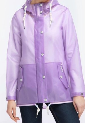 Imperméable violet semi-transparent avec une capuche, des pressions à l'avant, des cordons de serrage ajustables et deux poches à rabat, porté sur un pantalon foncé.