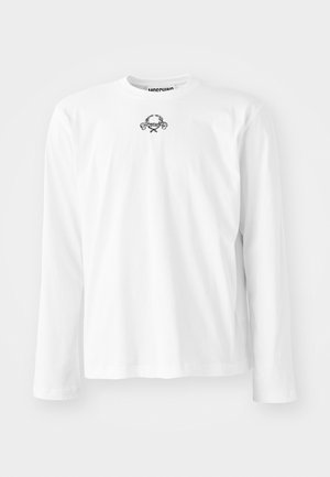 Camisa blanca de manga larga de algodón, con un cuello redondo y un pequeño diseño gráfico negro en el centro, con mangas con puños.