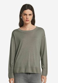 Långärmad, olivgrön tröja i mjukt material med en vid rund halsringning samt ribbade muddar och nederkant, med en avslappnad passform.