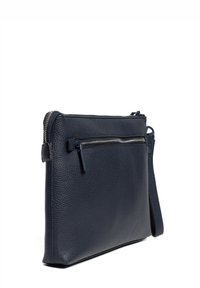 Mörkblå läderväska med texturerad yta, med en framficka med dragkedja och en avtagbar axelrem för bärning.