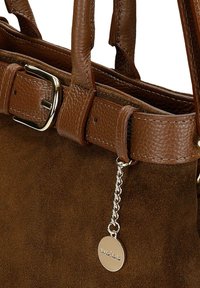 Bruine leren en suède handtas met een gestructureerde afwerking, zilveren hardware, een riemdetail en een gemerkt metalen charme aan een ketting.