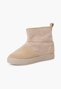 Botines beige con ante y tela acanalada. Punta redondeada, acentos texturizados y una pestaña en la parte posterior para facilitar el calzado. Suela de goma.