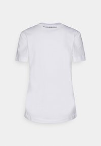 Weißes Baumwoll-T-Shirt mit kurzen Ärmeln, einem runden Halsausschnitt und dem Text "& Co.LLABORATION", der nahe dem Kragen auf der Rückseite gedruckt ist.