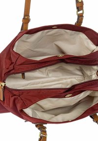 Rode stoffen handtas met een beige interieur. Heeft twee met rits gesloten compartimenten en bruine leren hengsels. Glad textuur met gouden hardware accenten.