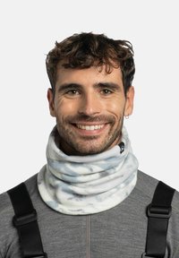 Cuello polar tipo braga con un patrón tie-dye en azul claro y blanco, textura suave y ajuste ceñido, usado con una camiseta gris y tirantes negros.