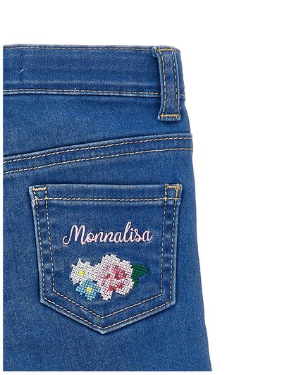 Μπλε τζιν τσέπη με μπεζ ραφές, κεντημένη με το όνομα "Monnalisa" και σταυροβελονιά με λουλούδια σε ροζ, λευκό, μπλε και πράσινο.