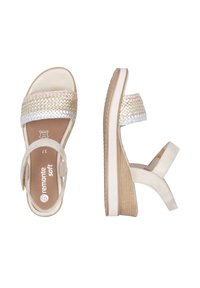 Beige woven sandals with a textured strap, featuring a light brown wedge heel with a white sole and adjustable ankle strap.