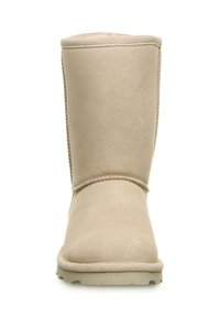 Helle beige Wildlederschuh mit runder Zehenpartie, genähten Details und flacher Gummisohle. Das Design ist einfach und schmucklos.