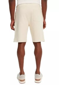 Beige shorts van zacht materiaal met een comfortabele pasvorm, voorzien van een elastische tailleband en een enkele achterzak. Rechte zoom en geen zichtbare patronen.
