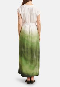 Maxi jurk van lichte stof, met een witte top die overgaat in een ombre groene onderkant, met een aangesnoerde taille en korte mouwen.