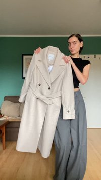 Διπλής όψης μπεζ παλτό με μεγάλους γιακάδες και ζώνη στη μέση. Διαθέτει κουμπιά διακοσμητικά και δομημένα μανίκια. Απαλή υφή.