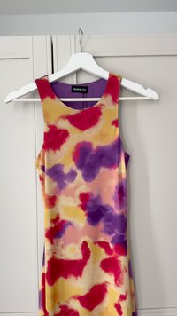 Mouwloze jurk met een kleurrijk abstract patroon in tinten roze, paars en geel. Gemaakt van gladde stof, met een ronde halslijn.