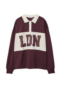 Mørkerød langærmet polo-shirt med en hvid vandret stribe, der har "LDN" i fed mørk skrift. Klassisk krave med tre knapper.