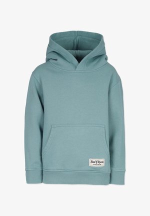 Huppari vaalean teallin värissä, valmistettu pehmeästä puuvillamateriaalista, jossa on etutasku ja ribbireunukset. Helmaan ommeltu etiketti lukee "Räyhäbändi."