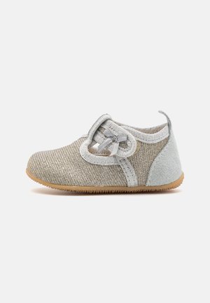 Miękkie buty dla malucha z teksturowaną jasnoszarą cholewką, regulowanym paskiem z kokardą, wyściełaną piętą i brązową elastyczną podeszwą.
