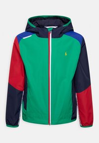 Kurtka przeciwwiatrowa w kolorowe panele: zielone, czerwone, granatowe i niebieskie, z zamkiem błyskawicznym z przodu, kapturem i logo na piersi. Lekka tkanina.