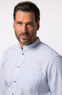 Camisa azul claro de botones con cuello mandarín, tejido texturizado y un bolsillo de parche en el lado izquierdo, con botones metálicos redondos.