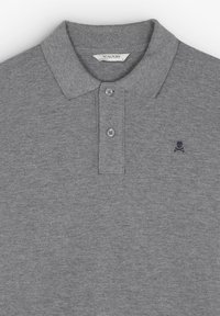 Polo gris de tejido texturizado, con cuello, tres botones y un pequeño logo de calavera navy en el lado izquierdo del pecho.