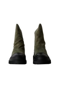 Stivaletti alla caviglia in suede verde oliva con punta a punta, suola in gomma nera e dettagli testurizzati sul tallone e sulla punta.