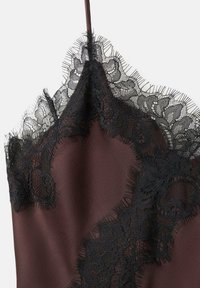 Vestido lencero color burdeos con intrincados detalles de encaje negro en el escote, bordes finos y textura de tela suave y lisa.