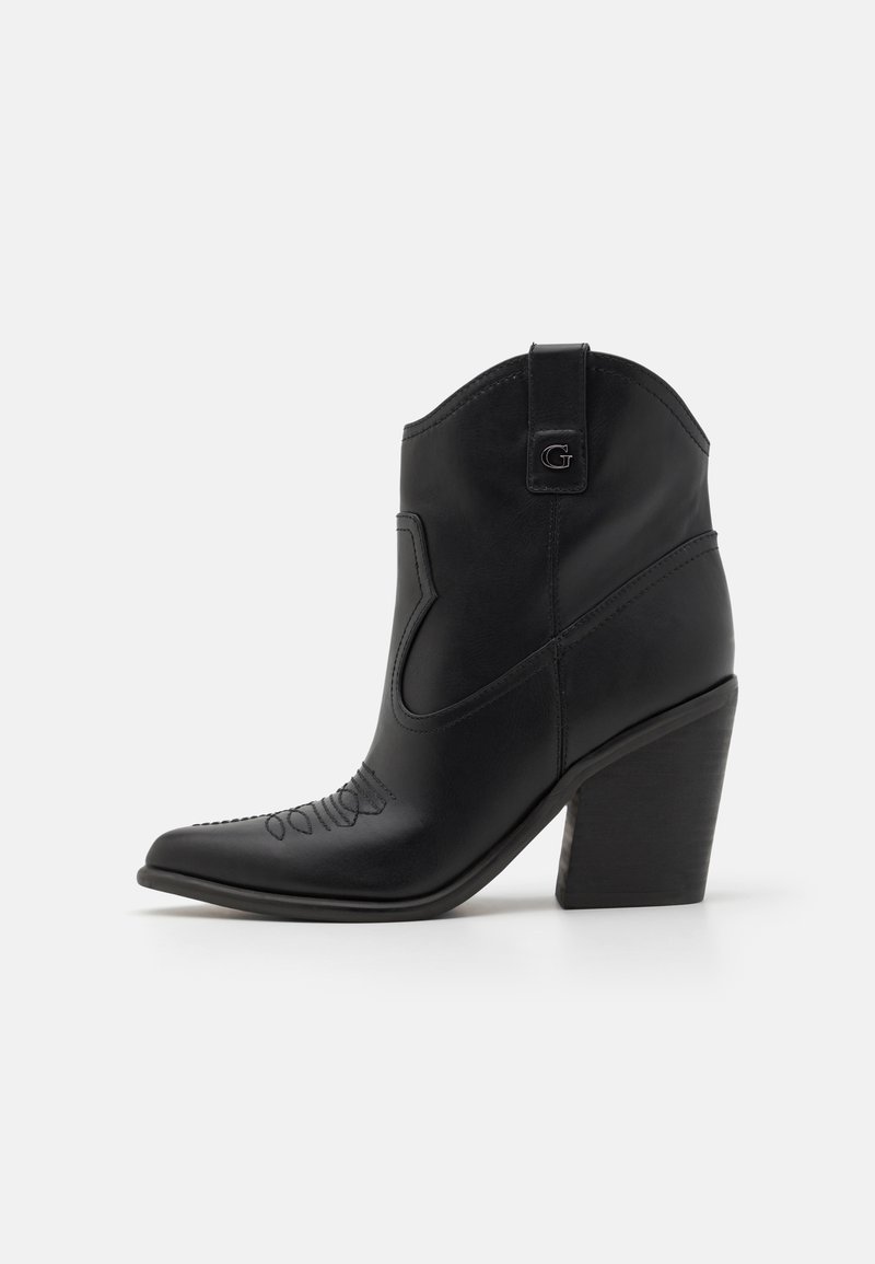 Botină din piele neagră până la gleznă, cu vârf ascuțit și design cusut. Prezintă un toc îngust și un mâner de tragere în spate.