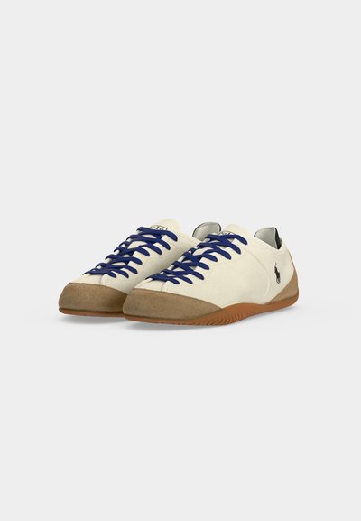 Λευκά casual sneakers με μπεζ σουέντ μύτες και σόλες, navy μπλε κορδόνια και μικρό μαύρο λογότυπο παίκτη πόλο στο πλάι.