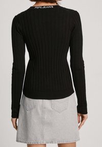 Černý žebrovaný top s dlouhými rukávy, s přiléhavým střihem, s kulatým výstřihem a značkováním "PEPE JEANS" vzadu, v kombinaci s světle šedou džínovou sukní.