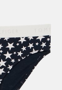 Ναυτικές βαμβακερές εσώρουχες με λευκό σχέδιο αστεριών. Η ζώνη είναι ανοιχτού γκρι με το "TOMMY" εκτυπωμένο με διακριτικό τρόπο.