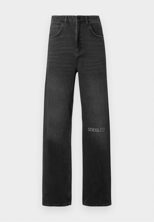 Jeans in denim nero con vestibilità rilassata, dotati di vita alta, cinque tasche e cuciture frontali. "STIEGLITZ" stampato in bianco sulla gamba.
