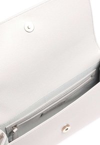 Light gray textured leather handbag interior with a zip pocket and card slots. Features a circular snap closure and smooth lining.