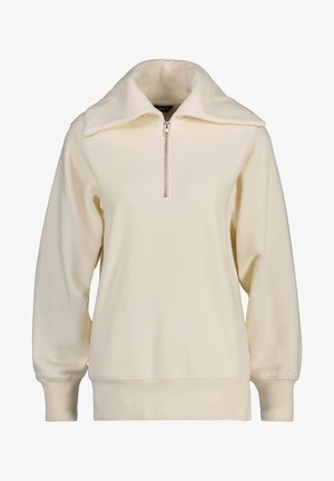 Sudadera de crema clara con cuello alto, cierre de cremallera frontal y puños acanalados. Tejido suave con un corte holgado y diseño minimalista.