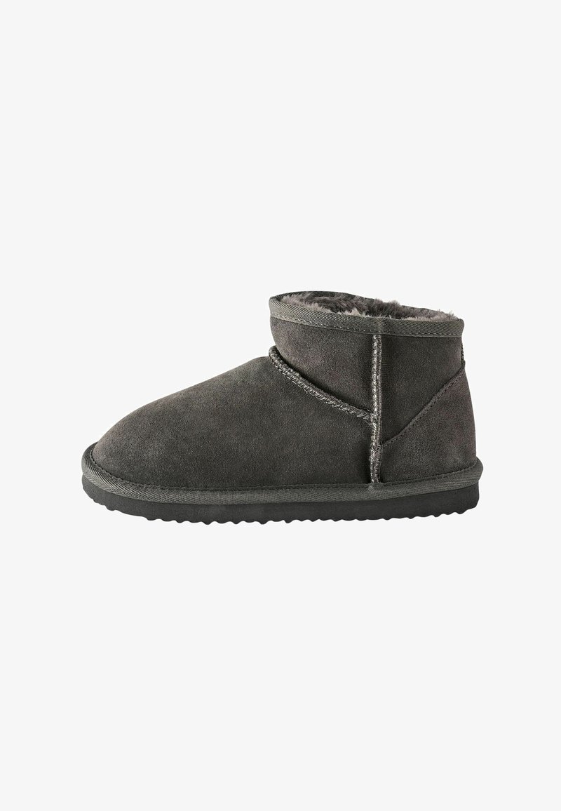 Grå mocka ankboot med en mjuk shearling-foder, kontrasterande sömmar och texturerad gummisula. Rund tå och låg höjddesign.