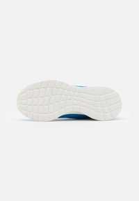 Chaussure de sport bleue avec une tige texturée, dotée d'une semelle extérieure en caoutchouc blanche avec un motif de semelle pour l'adhérence et la traction.