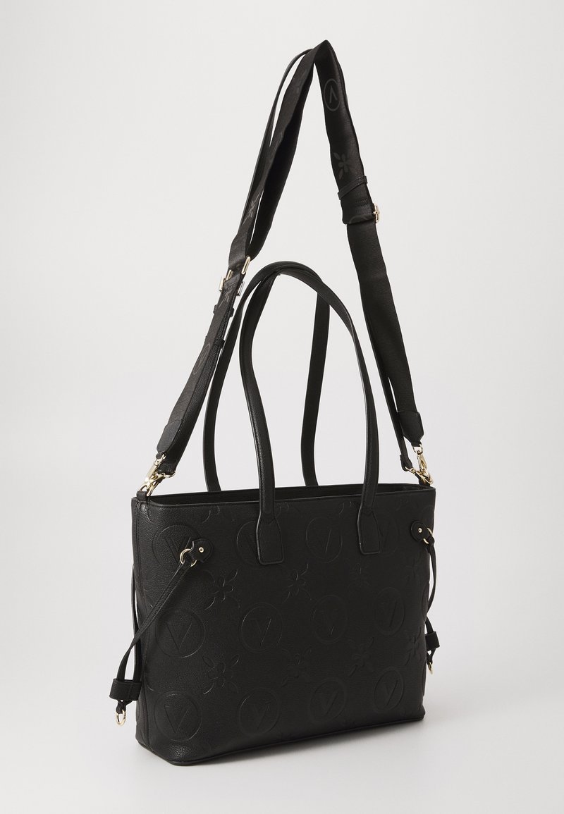 Borsa tote nera realizzata in materiale sintetico testurizzato, con motivi floreali e del logo in rilievo, doppi manici e una tracolla removibile.