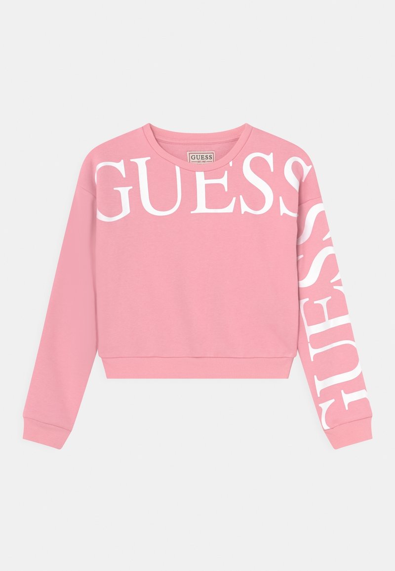 Pink sweatshirt with white "GUESS" text across the front and down the left sleeve. Made of soft material with ribbed cuffs and hem.
