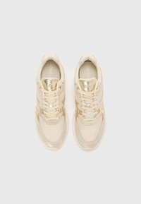 Sneaker beige con accenti metallici dorati, tomaia in rete e dettagli testurizzati sui lati. Presenta lacci piatti e colletto imbottito.