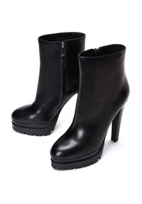 Zwarte leren enkelboots met een hoge stilettohak en een stevige plateauzool. Voorzien van een zijrits en een gladde, glanzende textuur.