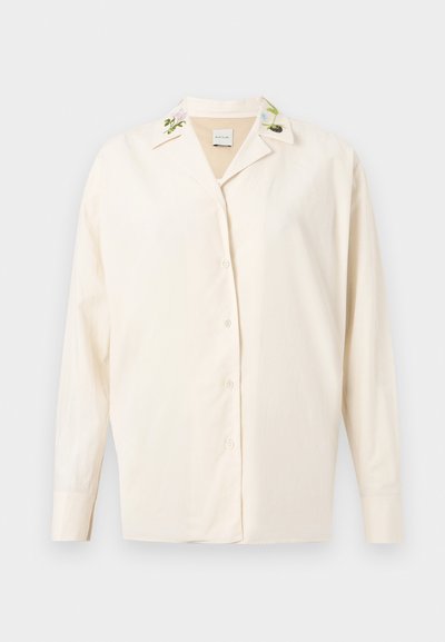 Camisa creme com botões, detalhes bordados de flores na gola, feita de um tecido suave, com mangas compridas e corte relaxado.