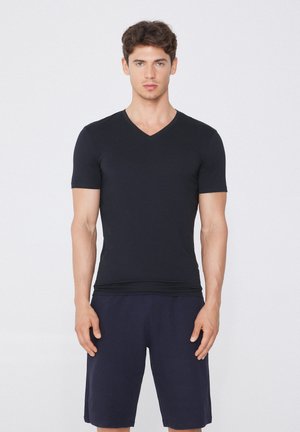 Czarny T-shirt z dekoltem w serek, wykonany z miękkiego materiału, z krótkimi rękawami i dopasowanym krojem, w zestawie z granatowymi szortami. Prosta, bezszwowa konstrukcja.