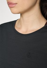 Czarna t-shirt sportowy z okrągłym dekoltem, teksturowanym materiałem oraz wytłoczonym logo lisa w lewym dolnym rogu.
