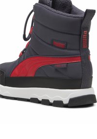 Felső része szürke textil, piros részletekkel és fekete gumitalppal rendelkező magasszárú sneaker. Puma logóval és texturált sarokkal rendelkezik.